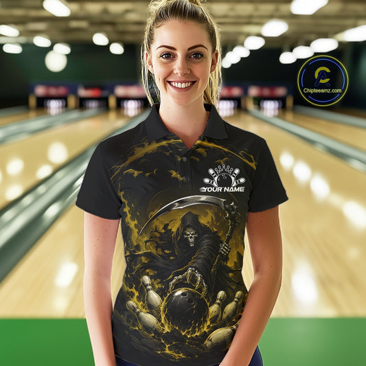 Front view of a female model wearing a black and yellow bowling polo shirt featuring a grim reaper commanding a blazing bowling ball crashing into scattered pins through swirling flames in a bowling lane.