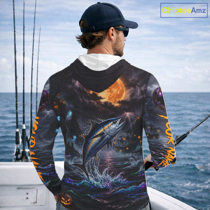 A man on a boat wearing a long-sleeve hoodie with a detailed all-over graphic print of a fish jumping from the water under a full moon, shown from the back.