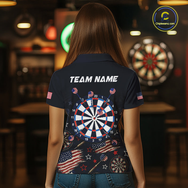 Back view of a woman wearing a custom navy dart polo with personalized team name and a distressed American flag graphic in a professional dart room.