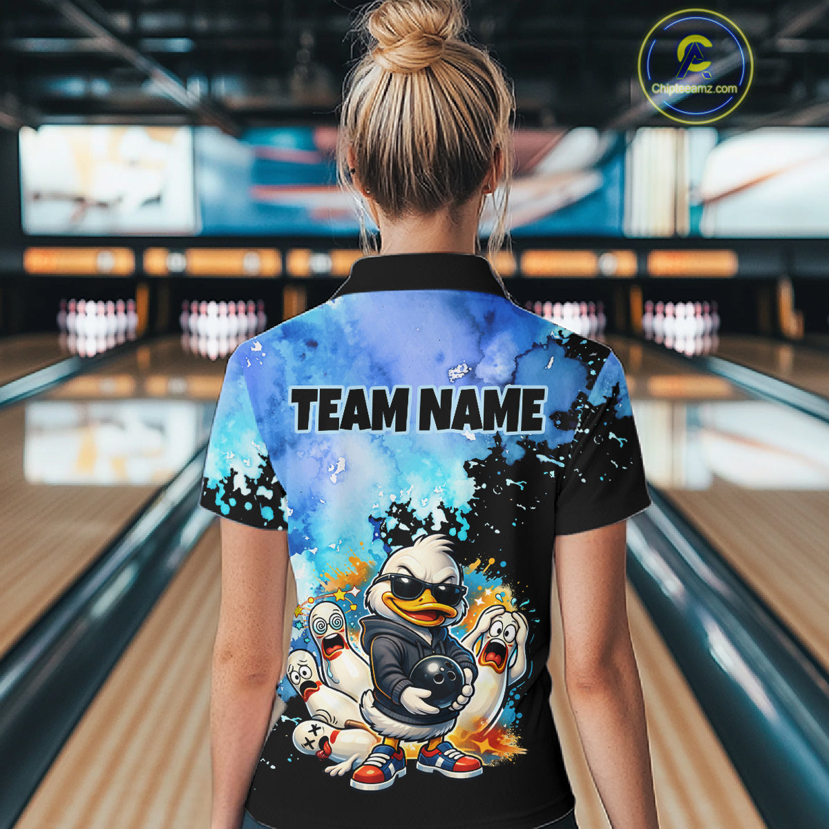 Person wearing a colorful shirt with cartoon characters and 'TEAM NAME' text in a bowling alley.