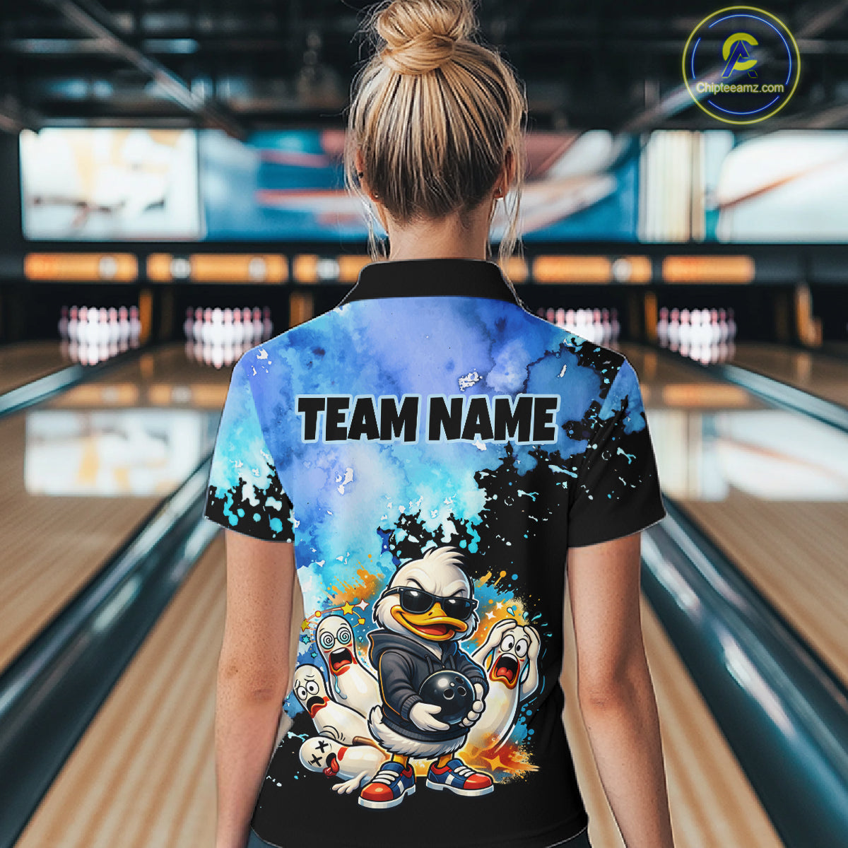 Person wearing a bowling shirt with cartoon characters and 'Team Name' text in a bowling alley.