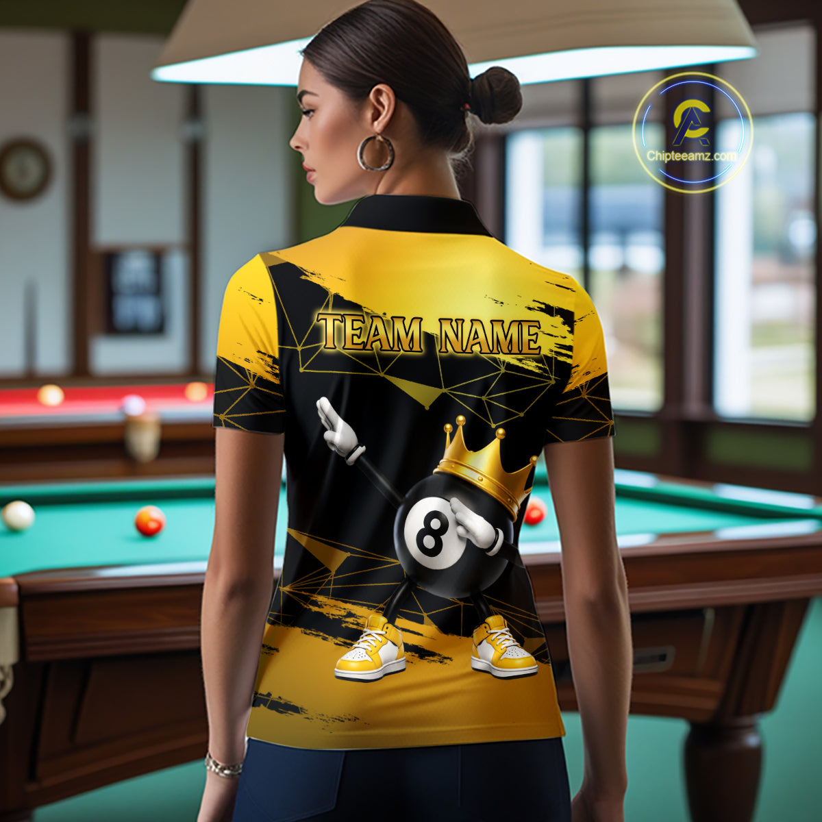 Back view of woman wearing custom black and gold geometric crown 8 ball billiard polo shirt in a billiard room showing personalized team name