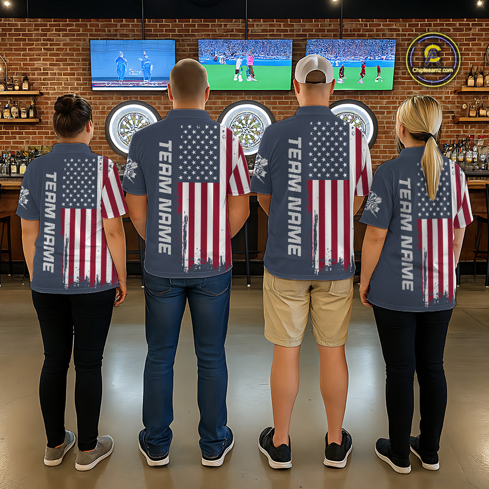 Four people standing with their backs to the camera in a bar, wearing matching navy blue t-shirts with a distressed American flag graphic on the back and 'TEAM NAME' printed vertically down the left shoulder.