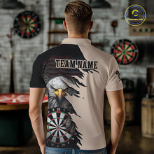 Load image into Gallery viewer, Person wearing a beige and black darts polo featuring a bald eagle, torn-flag graphics, dartboard designs, and custom team text.