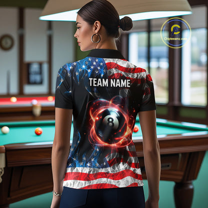 A woman stands in a billiards room wearing a custom short-sleeve polo shirt from the back. The shirt features a black base with a graphic of an 8-ball surrounded by red and orange energy swirls, and the American flag pattern on the upper back and shoulders.