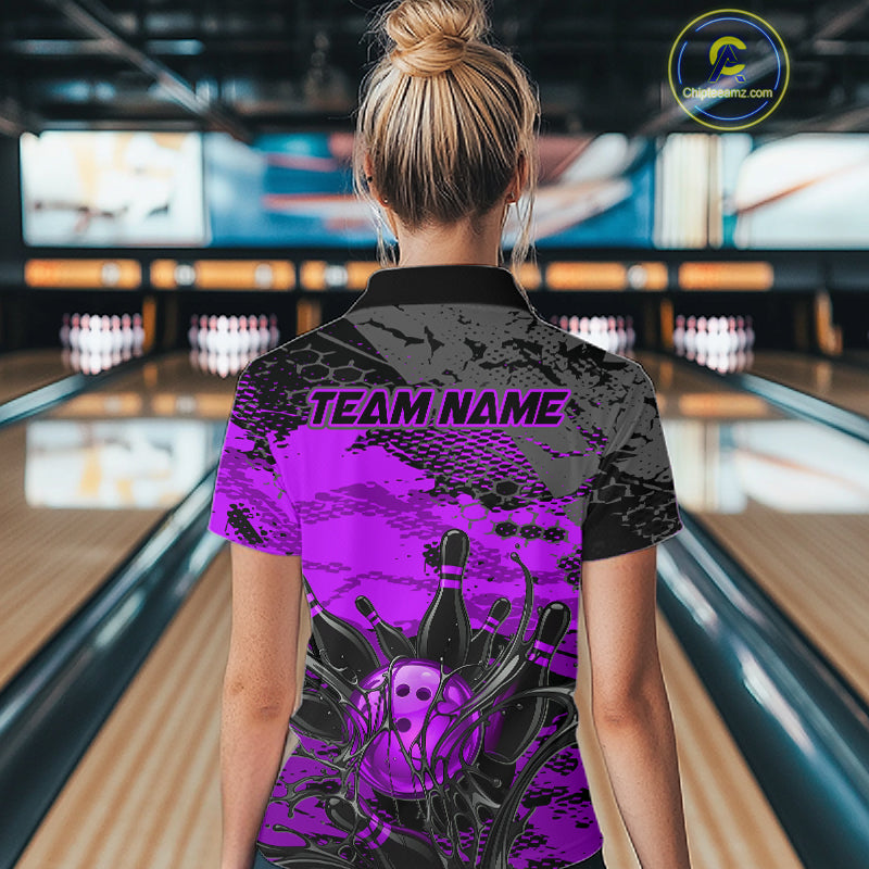 Person wearing a purple and black bowling shirt with 'TEAM NAME' on a bowling alley.