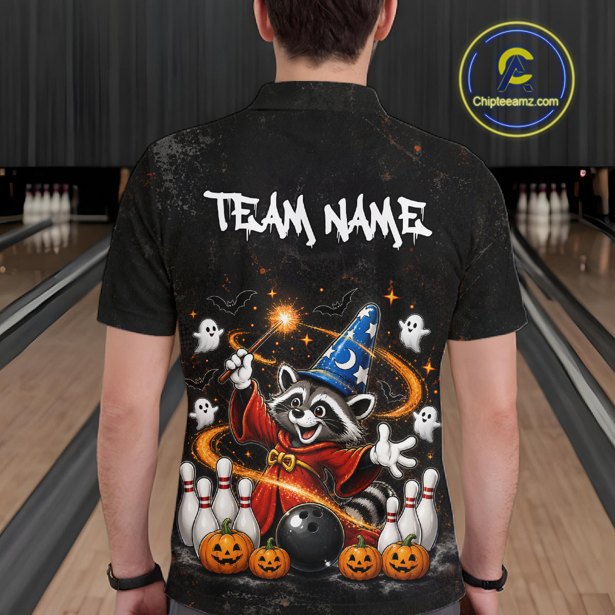 A person viewed from behind wearing a black short-sleeve button-up shirt with a large Halloween-themed graphic on the back. The design shows a raccoon in a wizard hat and robe with ghosts, pumpkins, bowling pins, and a bowling ball, plus the text 'TEAM NAME'.