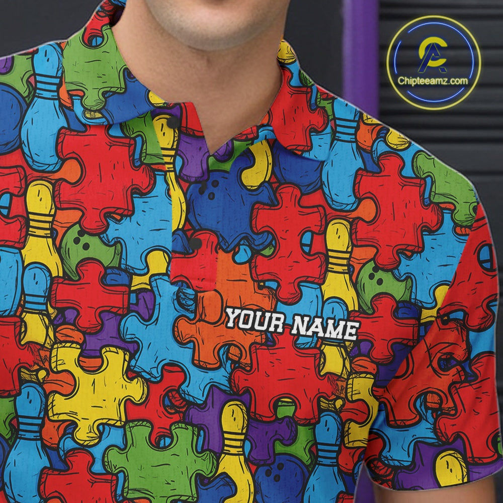 A close-up of a person wearing a short-sleeve polo shirt with a colorful puzzle-piece pattern and bowling pins. The shirt has a custom placeholder text 'YOUR NAME' printed on the chest.