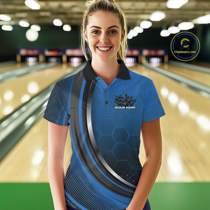 Female model in a bowling lane wearing a black and blue polo shirt with honeycomb texture and a flaming bowling strike graphic.
