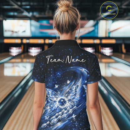 Back view of a female model in a bowling alley wearing a blue polo shirt featuring glowing butterfly wings and galaxy-themed bowling graphics.