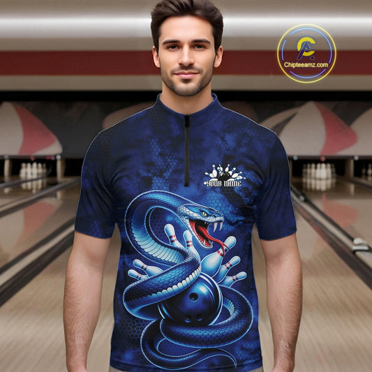 Male model wearing a bowling quarter-zip in a bowling alley with blue cobra artwork surrounding a bowling ball and scattered bowling pins.