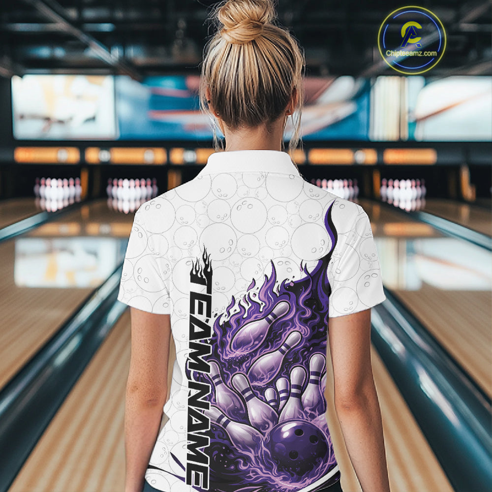 Back view female model in bowling lane wearing white, blue and purple quarter zip featuring flaming bowling ball striking pins with dynamic cosmic fiery graphics.