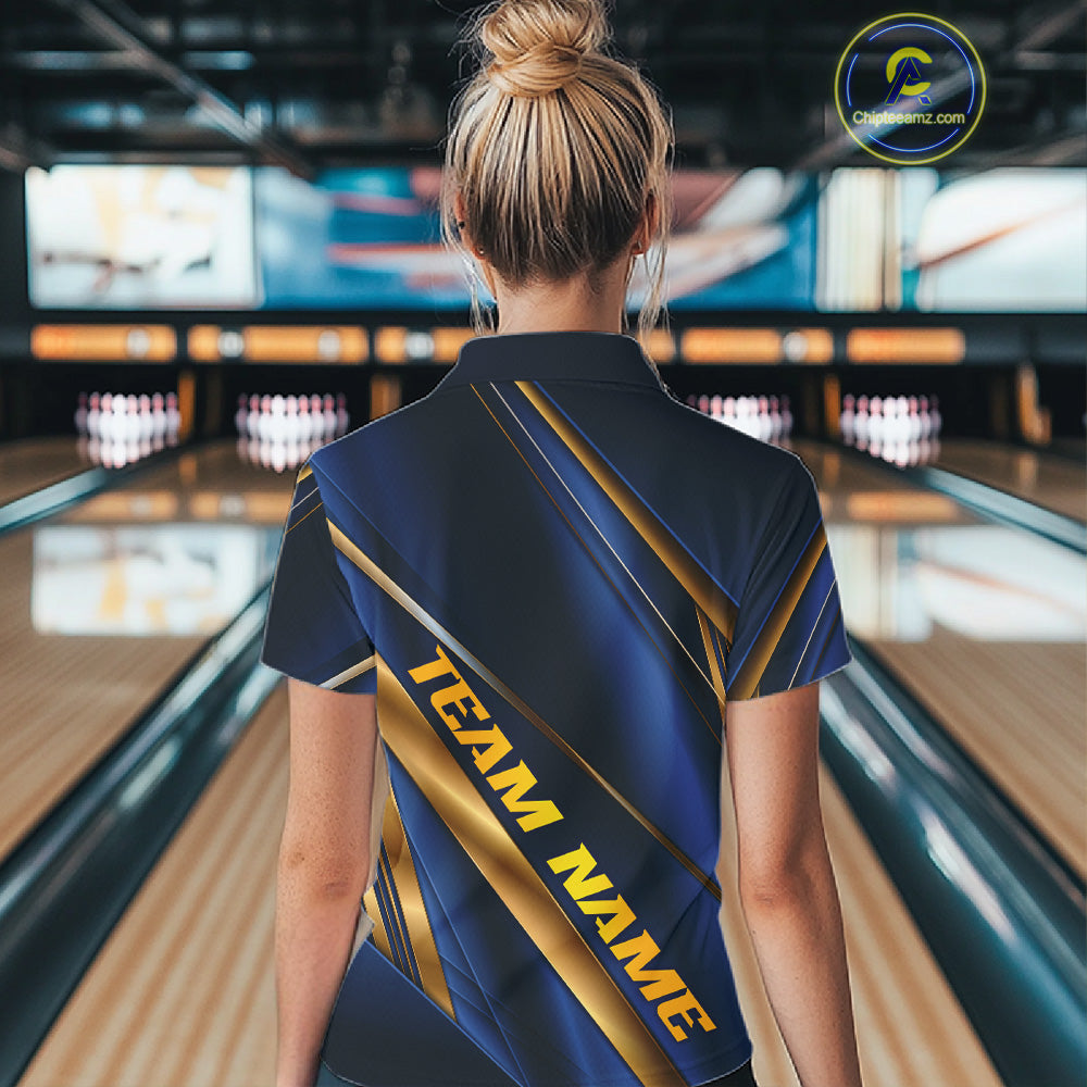 A woman viewed from behind wearing a dark blue bowling shirt with gold diagonal stripes and the text 'TEAM NAME' on the back, standing in a bowling alley.