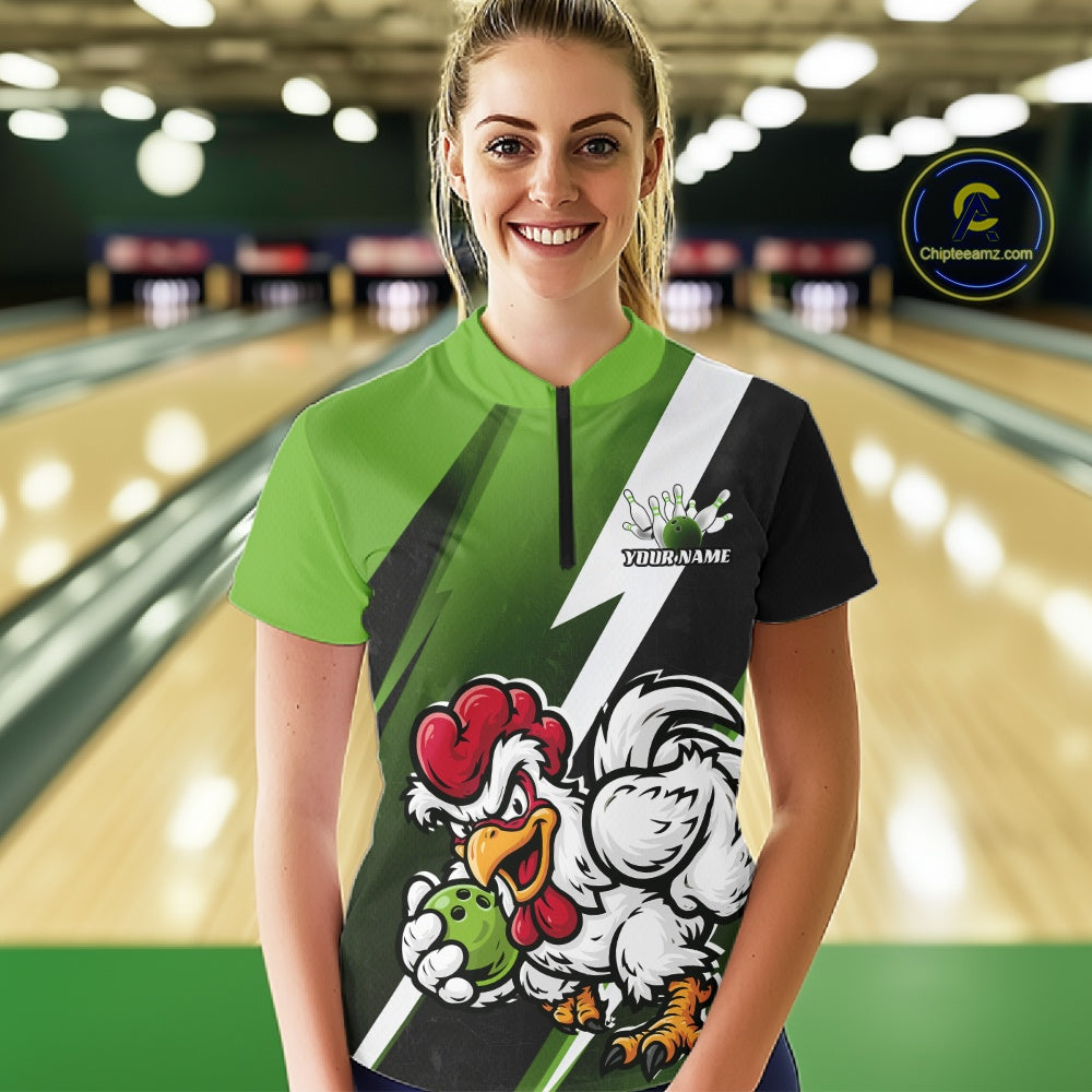 A woman standing in a bowling alley wearing a custom short-sleeve bowling t-shirt with a green, black, and white design featuring a cartoon rooster mascot and the text 'Your Name'.
