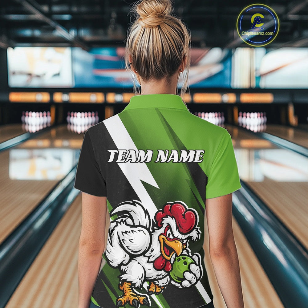 A woman viewed from behind wearing a custom short-sleeve polo shirt in a bowling alley. The back of the shirt features a green and black graphic design with a white lightning bolt, the text 'TEAM NAME', and a cartoon rooster holding a bowling ball.