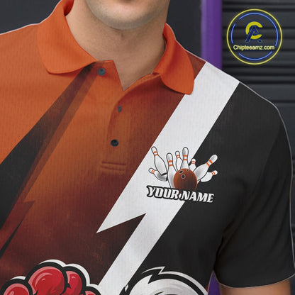 A close-up of a custom short-sleeve polo shirt featuring a bold diagonal split design with orange on one side and black on the other, divided by a white lightning bolt. The shirt has a bowling-themed graphic on the black side with the text 'YOUR NAME' 
