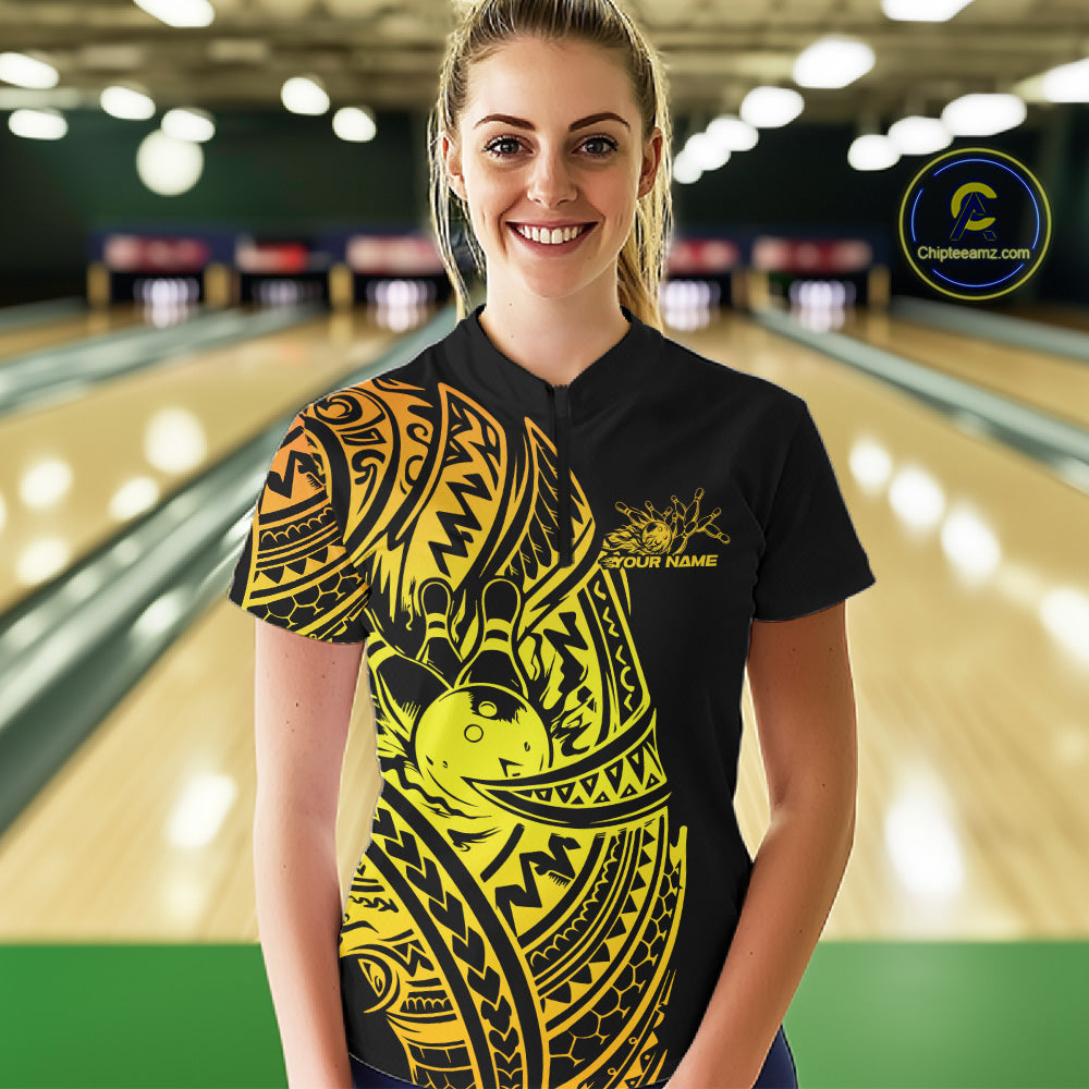 Female model wearing a black and gold bowling quarter-zip shirt at the lane with Polynesian-style bowling artwork.