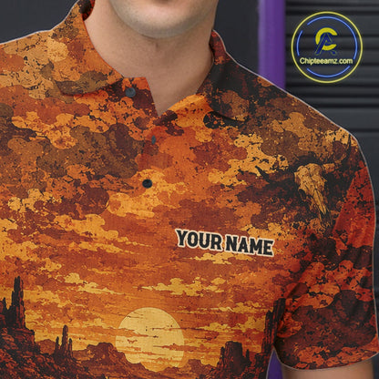 A close-up of a man wearing a short-sleeve polo shirt with a desert sunset print in orange, brown, and yellow.