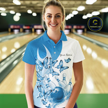 Load image into Gallery viewer, Female model wearing a white and blue bowling polo with butterfly artwork and bowling graphics, front view inside a bowling center