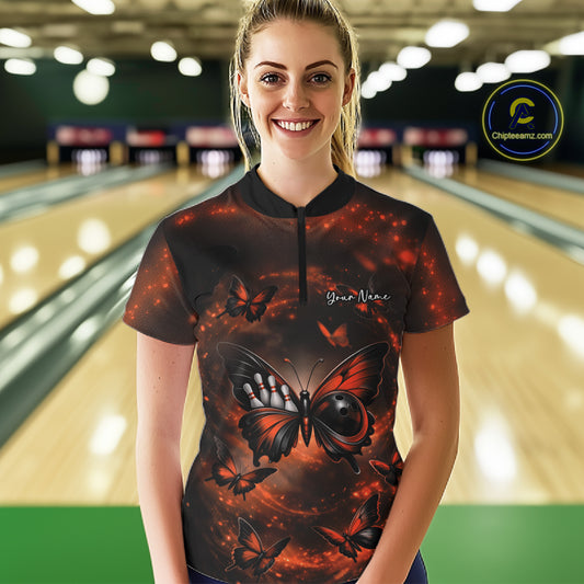 Female model at a bowling lane wearing a quarter-zip bowling shirt featuring an orange and black butterfly with a bowling ball body against a smoky backdrop.