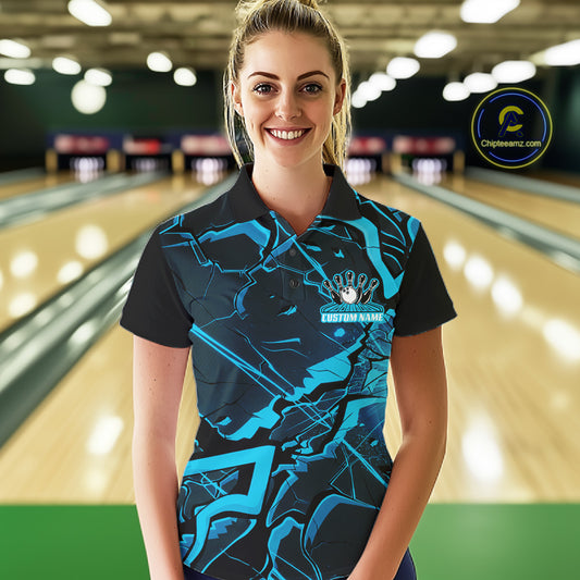 Female model in a bowling alley wearing a black and blue polo with angular cracked pattern graphics.