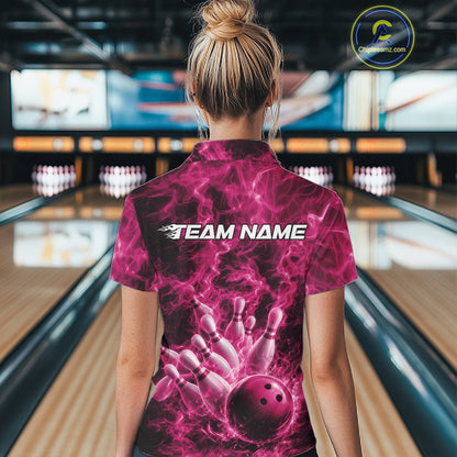 Back view of a womens bowling quarter-zip showcasing a pink bowling ball striking pins against a fiery background.