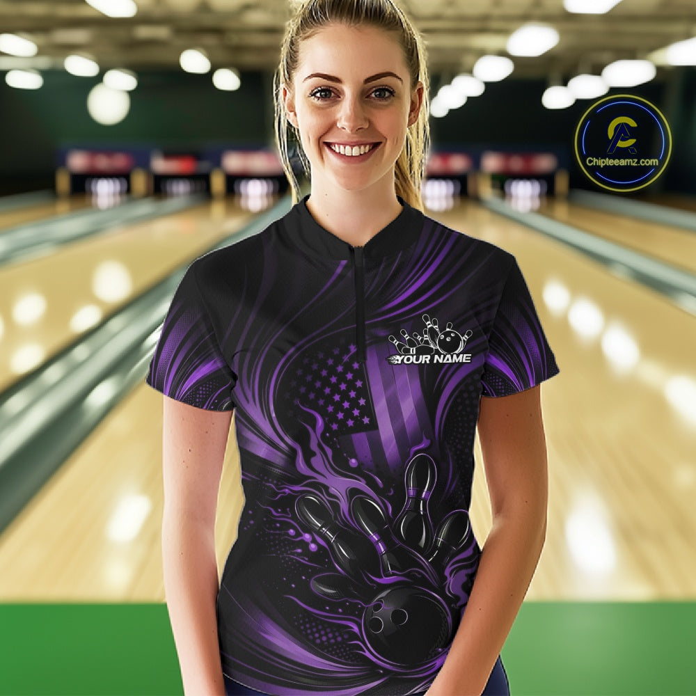 Female model at a bowling lane wearing a black and purple bowling quarter-zip shirt with patriotic bowling strike graphics and fiery details.