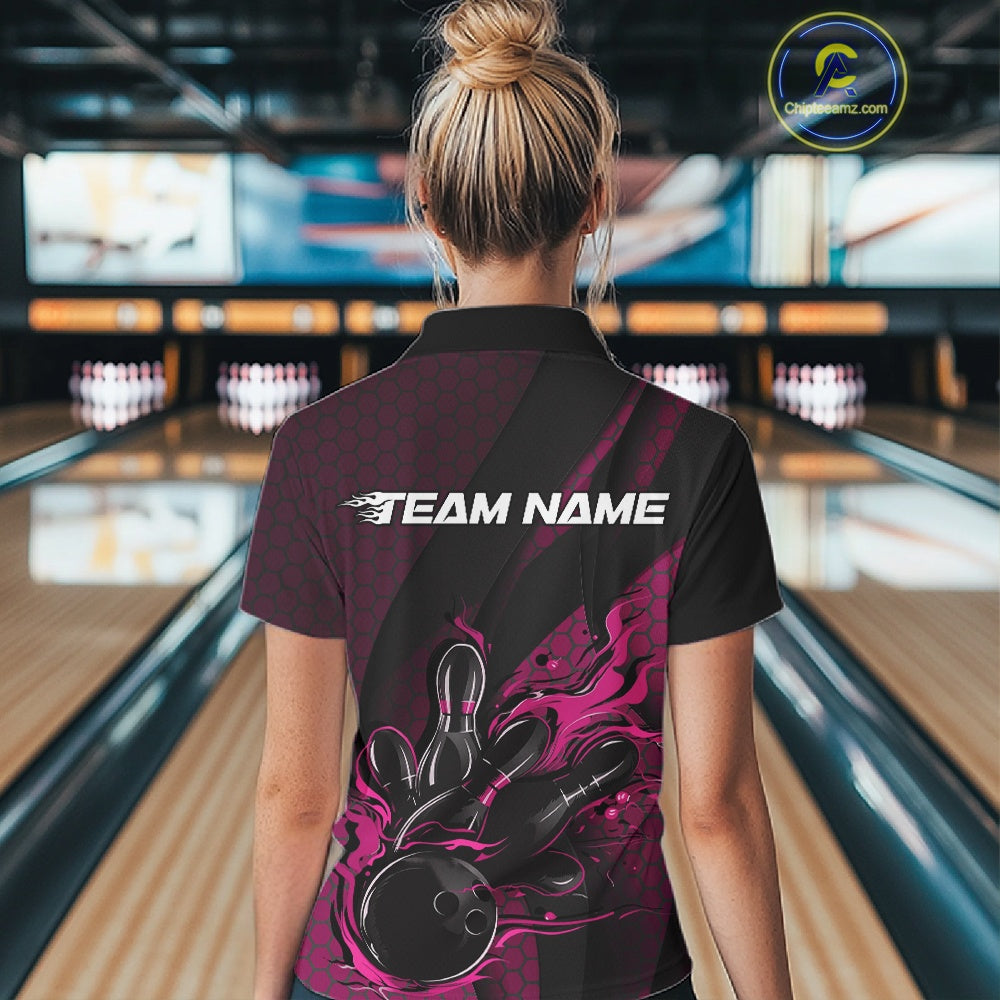 Female model inside a bowling center, back view of black and pink quarter zip shirt highlighting fiery bowling ball striking pins with abstract patterned details