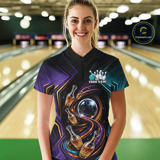 A woman stands in a bowling alley wearing a custom bowling shirt with a black collar and a vibrant graphic print featuring bowling pins that resemble wine bottles and bowling ball on a swirling cosmic background.