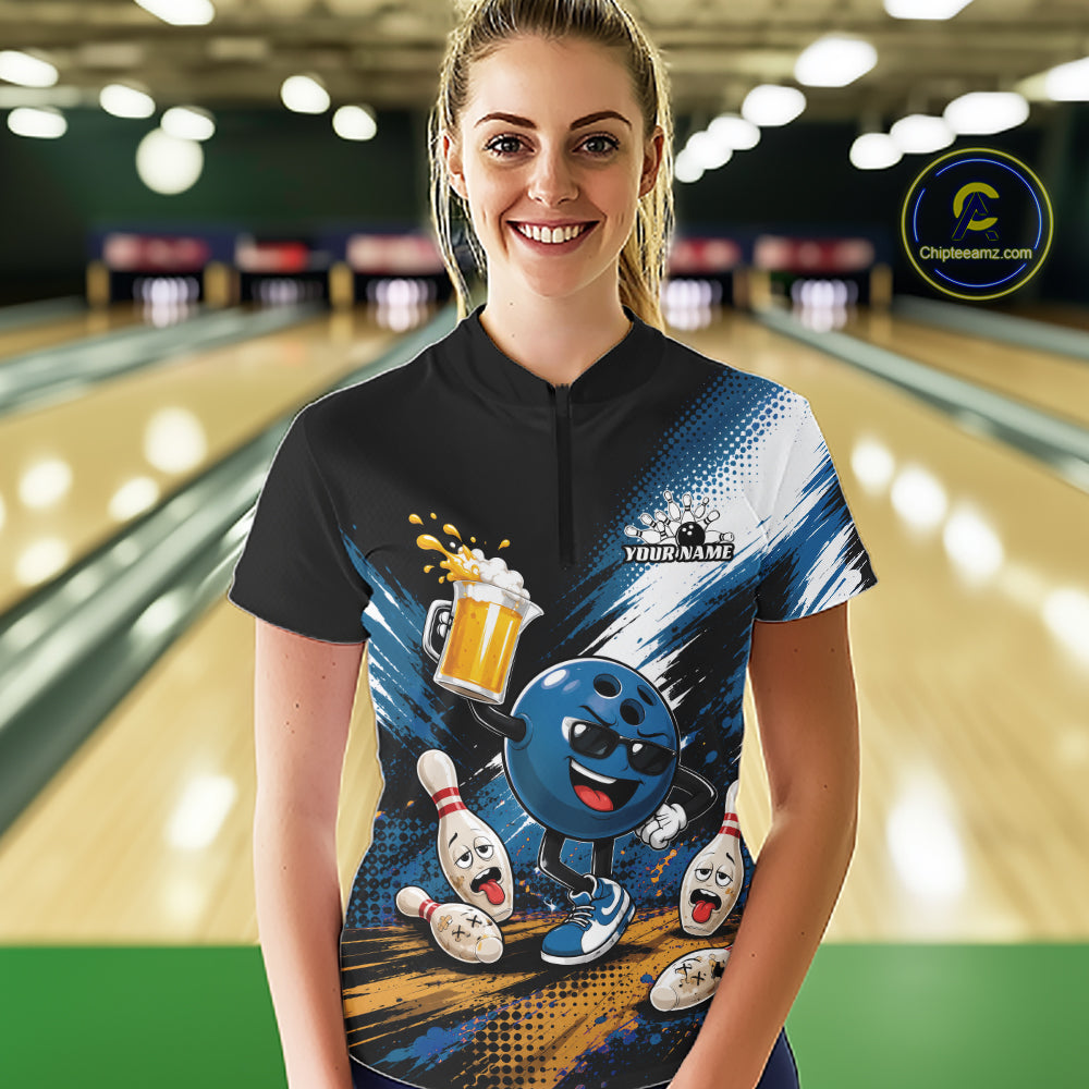 A woman stands in a bowling alley wearing a custom short-sleeve bowling t-shirt. The shirt features a black collar and upper chest, transitioning into a blue and white graphic design with a cartoon bowling ball character, bowling pins, and a beer mug.