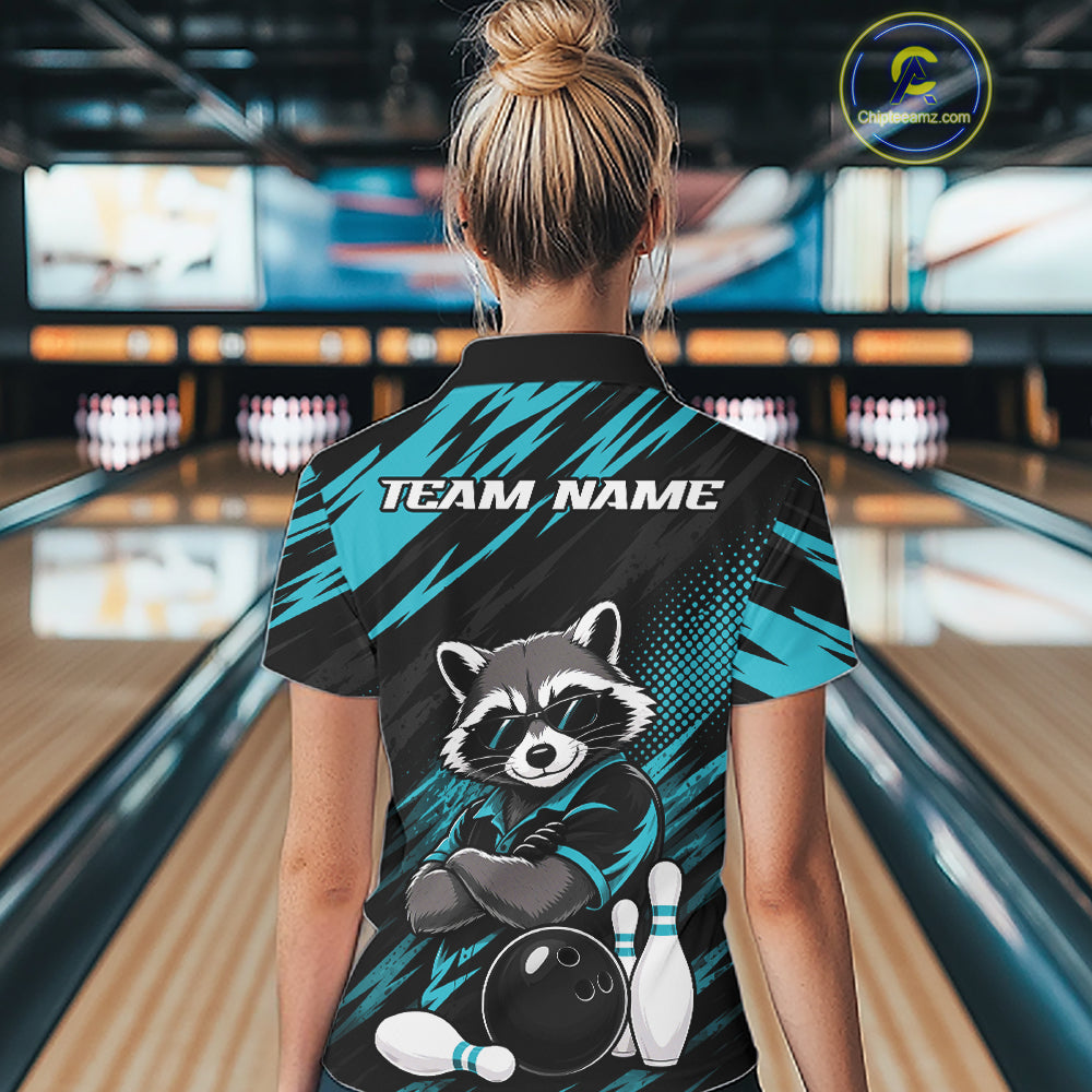 A woman viewed from behind wearing a bowling-themed short-sleeve quarter zip shirt in a bowling alley. The back of the shirt features a raccoon graphic with bowling pins and ball, the text 'TEAM NAME', and a teal and black patterned design.