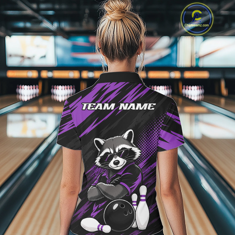 A woman viewed from behind wearing a custom bowling-themed short-sleeve quarter zip shirt with a raccoon graphic and 'TEAM NAME' text on the back, standing in a bowling alley.
