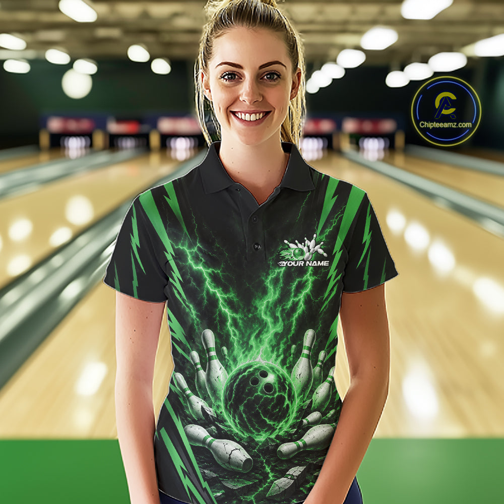 A woman wearing a custom black and green bowling-themed polo shirt with a lightning bolt and bowling hand graphic, standing in front of a blurred bowling alley background.