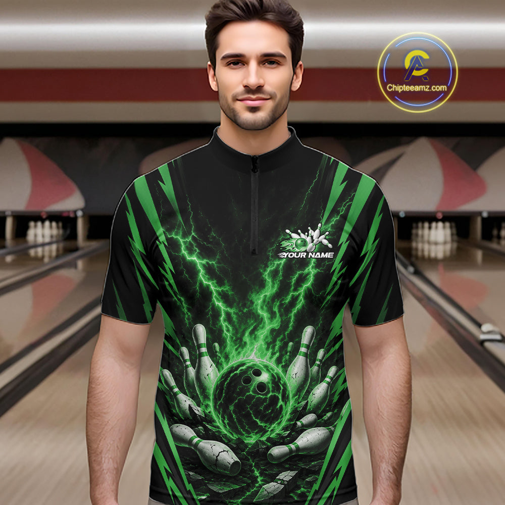 A man wearing a black short-sleeve quarter-zip shirt with a green and black bowling-themed graphic print, standing in a bowling alley. The shirt features a green lightning bolt design, bowling pins, a bowling ball