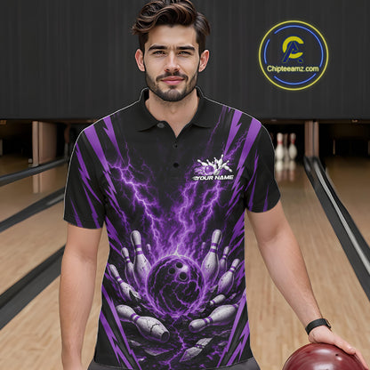 A man wearing a black short-sleeve bowling-themed polo shirt with a purple lightning and bowling pins graphic, standing in a bowling alley. 