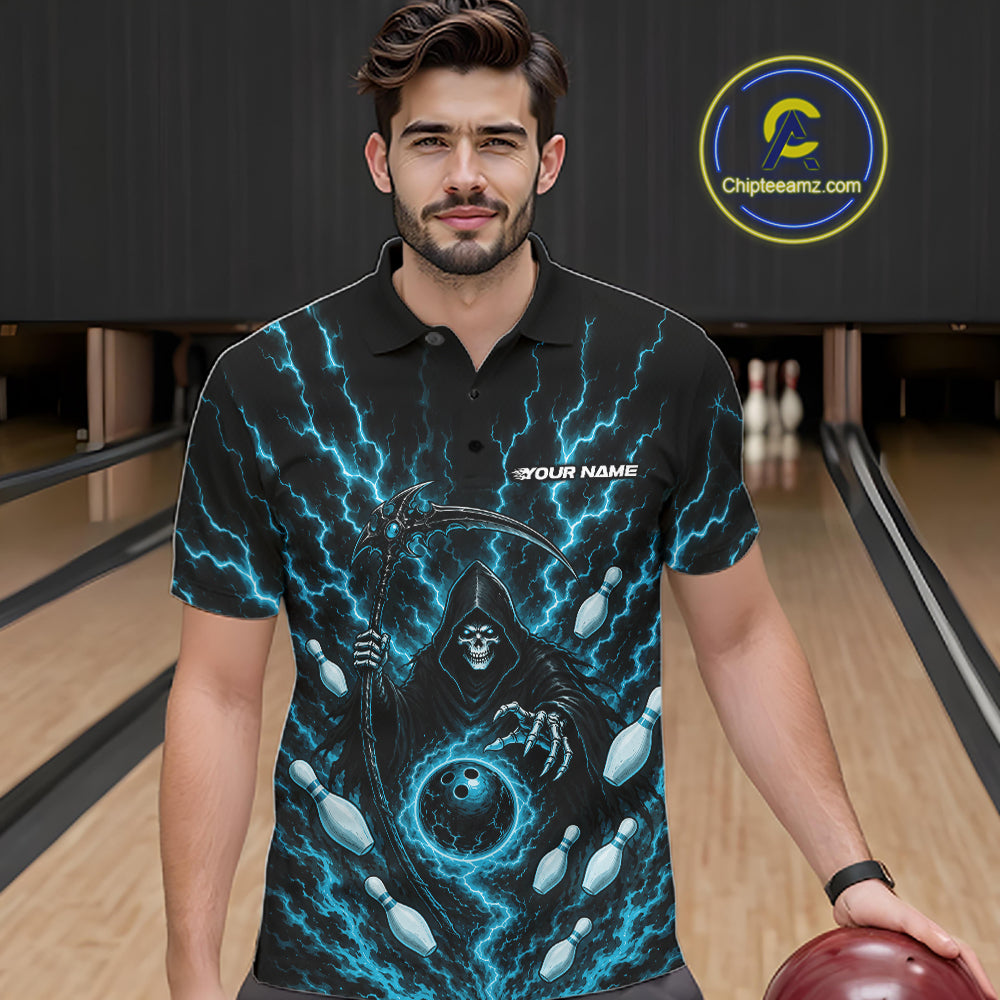 A man wearing a black short-sleeve polo shirt with a blue lightning and grim reaper graphic, standing in a bowling alley holding a bowling ball. 