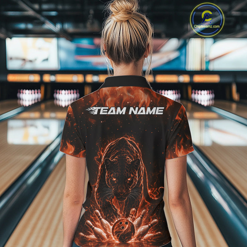 Back view of a female model in a bowling lane wearing a black quarter-zip shirt featuring glowing electric panther artwork with bowling strike action graphics.