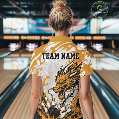 Person wearing a yellow bowling shirt with a dragon design and 'TEAM NAME' text in a bowling alley.