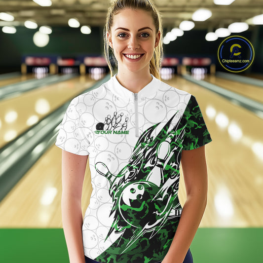 Female model wearing a white bowling quarter-zip shirt at the lane with green camo bowling graphics and subtle bowling ball patterns.