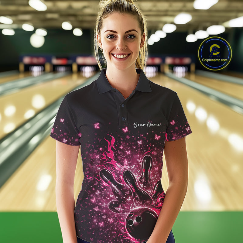 Female model wearing a black and pink bowling polo shirt at the lane with flaming bowling ball artwork.