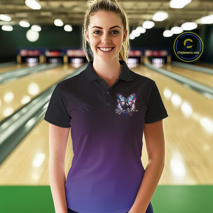 Female model wearing a colorful bowling polo shirt at a bowling lane with glowing butterfly artwork, a bowling ball, and fallen bowling pins.