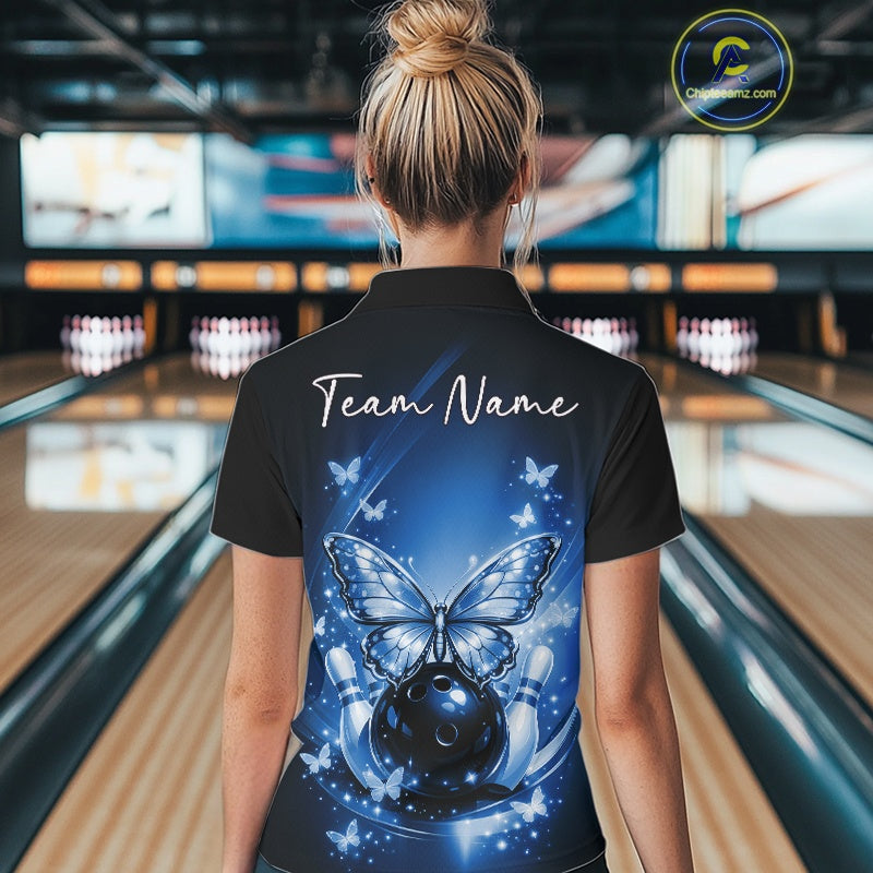 Back view of a female model in a bowling venue wearing a blue polo shirt showcasing luminous butterflies and cosmic bowling artwork.