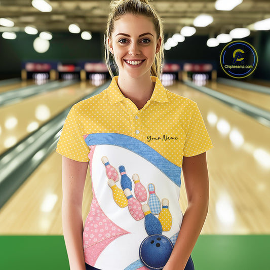 Female model at a bowling lane wearing a bowling polo shirt with vibrant patchwork bowling ball and pin graphics accented by polka dots.