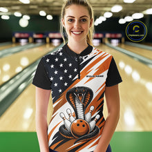 Load image into Gallery viewer, A woman stands in a bowling alley wearing a black, white, and orange bowling shirt with stars, diagonal stripes, a cobra, pins, and an orange ball.