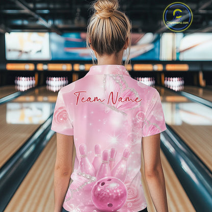 Back view of a female model in a bowling alley wearing a bowling polo shirt featuring pink glitter butterflies and bowling-themed graphics.