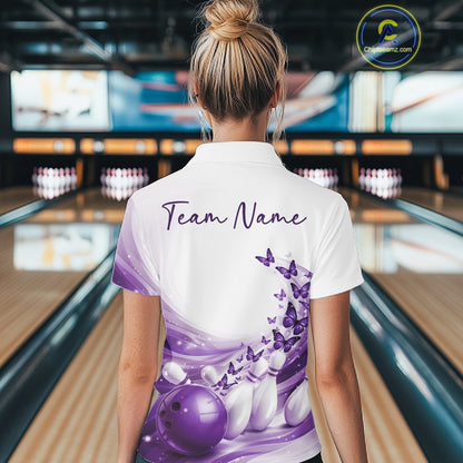 Back view of a white and purple bowling quarter zip with butterfly accents and bowling graphics inside a bowling center.