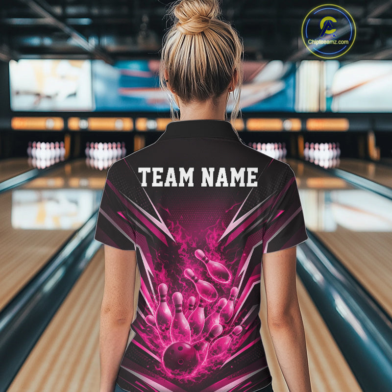 Back view female model in bowling lane wearing black and pink quarter zip featuring flaming bowling ball striking pins with dynamic fiery action graphics.