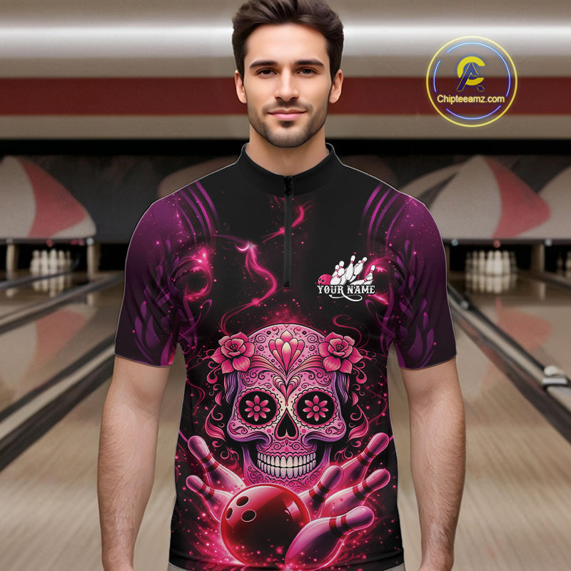 Male model at a bowling lane wearing a black and pink bowling quarter-zip shirt with vibrant sugar skull artwork and bowling-themed details.