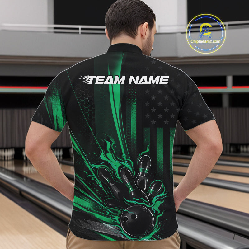 Front view of a male model in a bowling center wearing a black and green quarter-zip shirt featuring a patriotic bowling ball knocking down pins.