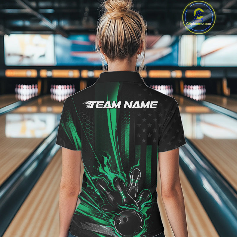 Back view of a female model in a bowling venue wearing a black and green quarter-zip shirt featuring a bowling ball knocking down pins with patriotic styling.